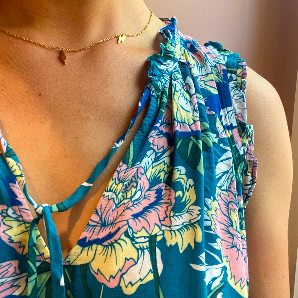 adorable floral top with delicate ruffled trim and loose neck tie